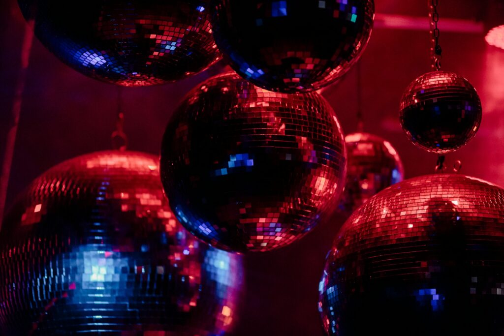 Colorful disco balls illuminated by vibrant red and blue lights, capturing the party vibe near Budapest stag do accommodation options