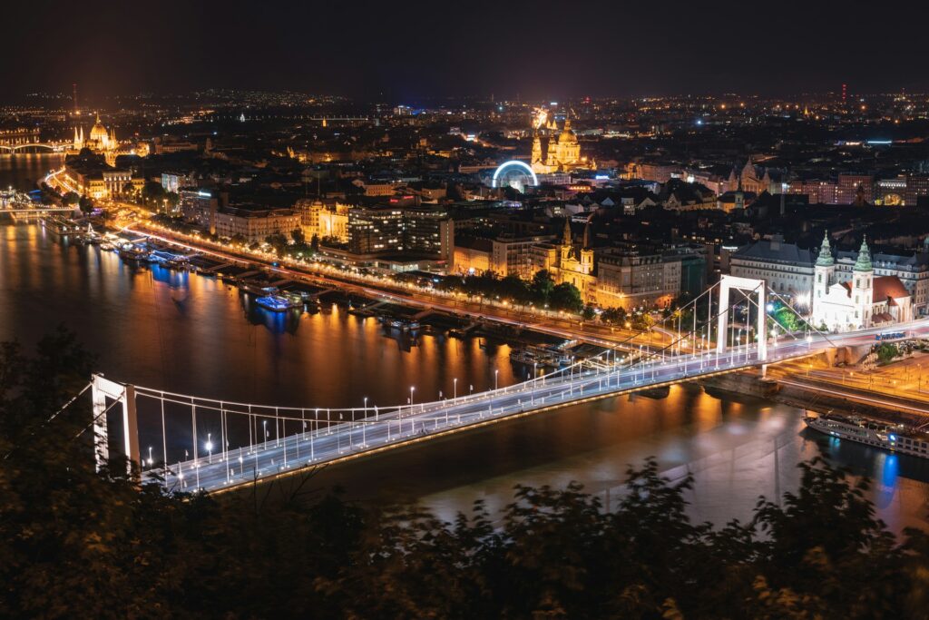 Scenic view of Budapest featuring the Chain Bridge, St. Stephen’s Basilica, and the Danube River during twilight, highlighting the city's charm.