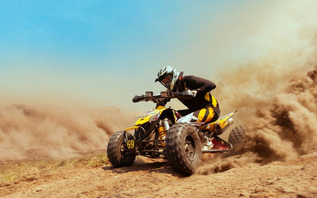 Rider speeding through dusty terrain on a quad bike, capturing the excitement of quad driving Budapest stag activities.