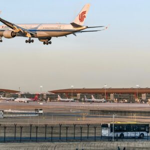 Airplane landing at an airport with a shuttle bus in the foreground, representing seamless airport shuttle Budapest stag services