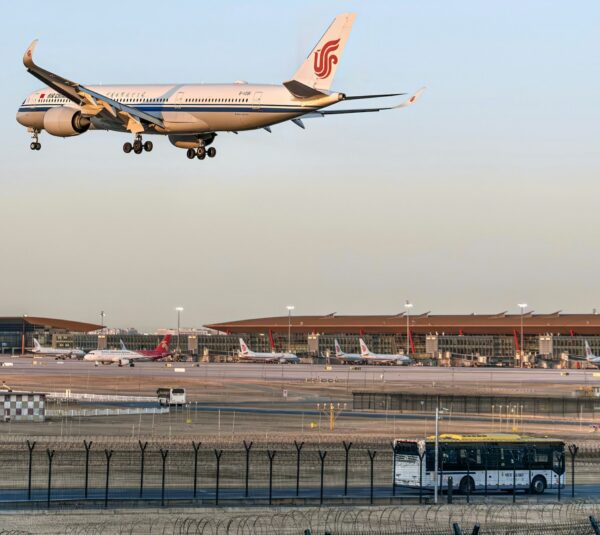 Airplane landing at an airport with a shuttle bus in the foreground, representing seamless airport shuttle Budapest stag services