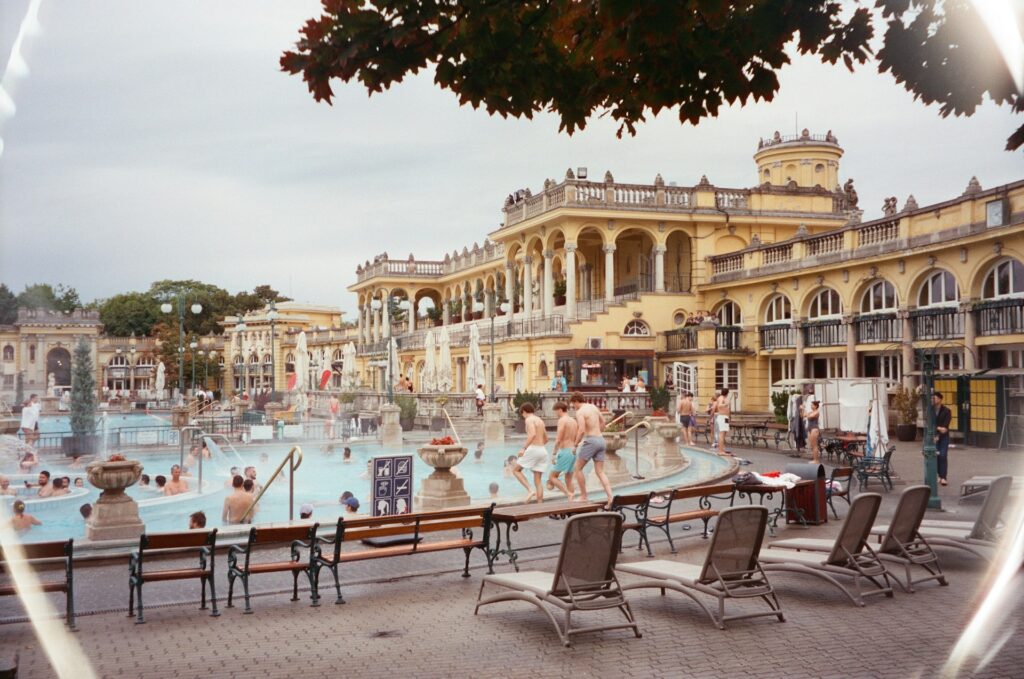 A lively scene at Budapest's Széchenyi Thermal Bath, a popular spot for stag do activities, featuring historic architecture, outdoor pools, and a relaxed atmosphere.