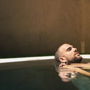 Man relaxing in a tranquil pool, capturing the rejuvenating experience of a spa visit during a Budapest stag detox activity.