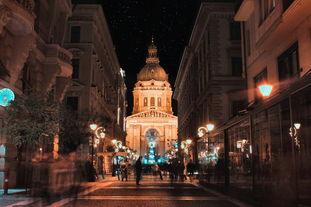 Night view of St. Stephen’s Basilica in Budapest, surrounded by illuminated streets near popular Budapest stag do accommodation options