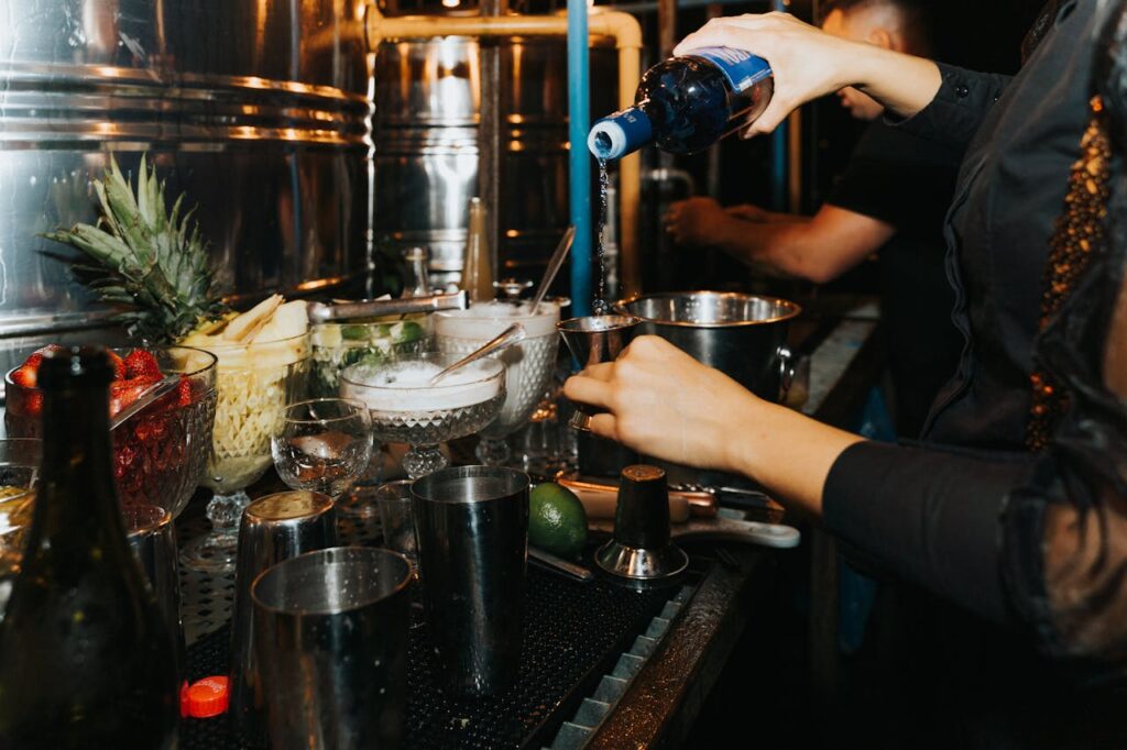 Bartender preparing cocktails with fresh ingredients, showcasing a lively nightlife scene with a focus on premium drinks and atmosphere.
