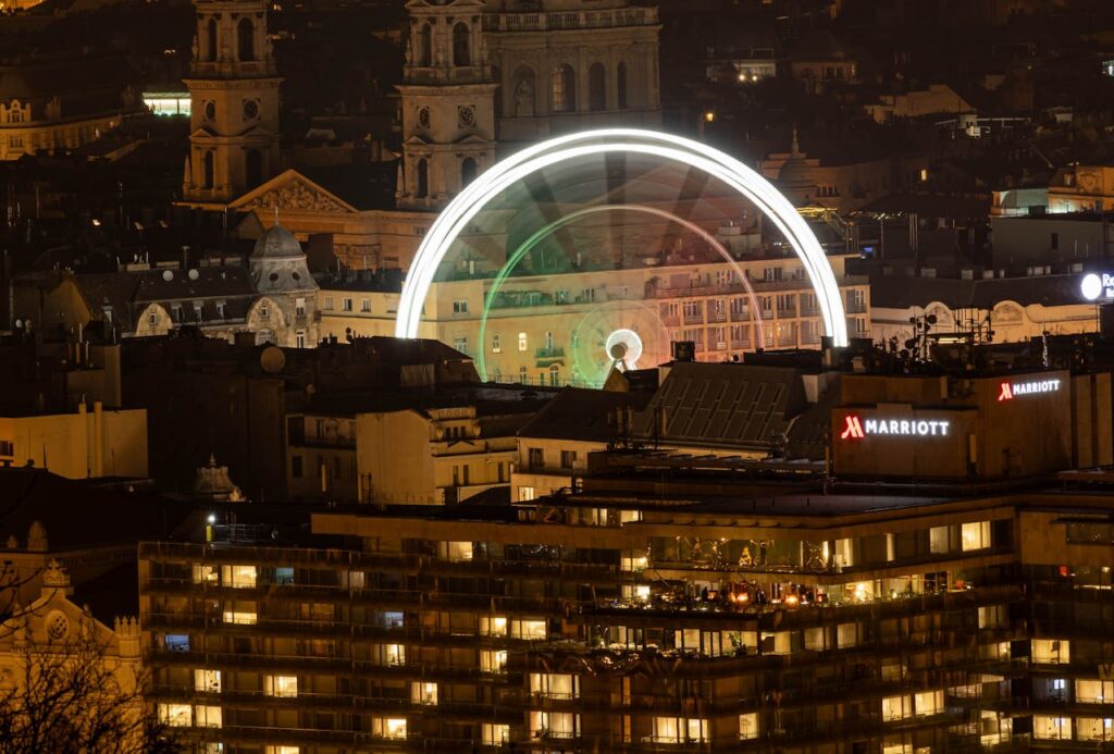 Nighttime view of Budapest with a lit-up Ferris wheel near popular Budapest stag do accommodation options in the city center