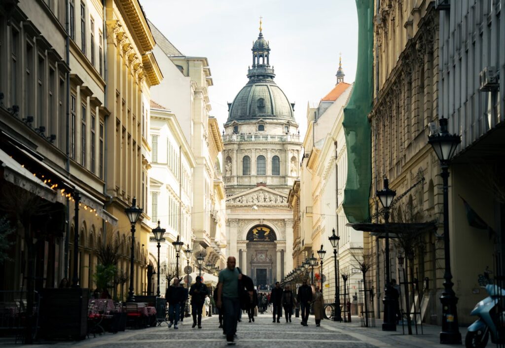A picturesque street in Budapest leading to St. Stephen’s Basilica, surrounded by historic buildings and outdoor cafes
