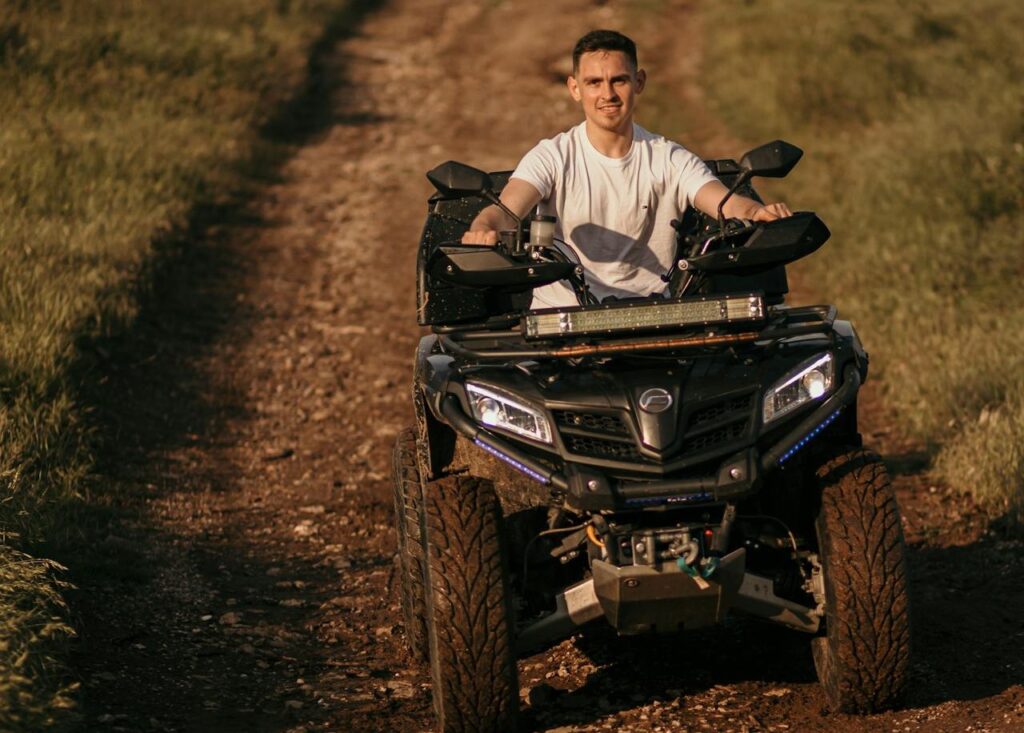 A man riding a quad bike on a dirt path, showcasing the thrill of outdoor adventures included in Budapest stag party packages