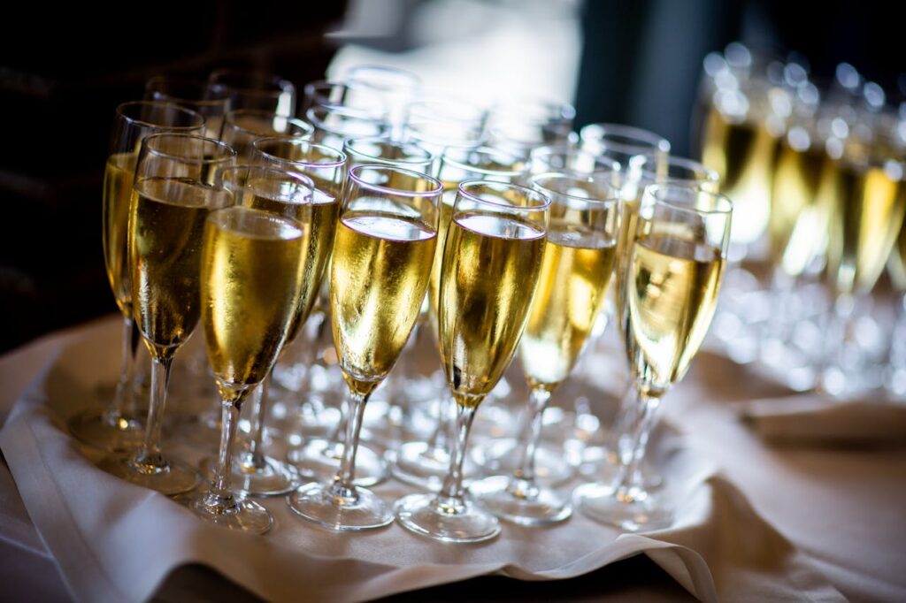 A close-up of several glasses of sparkling champagne on a white cloth, arranged for a celebratory occasion or party.